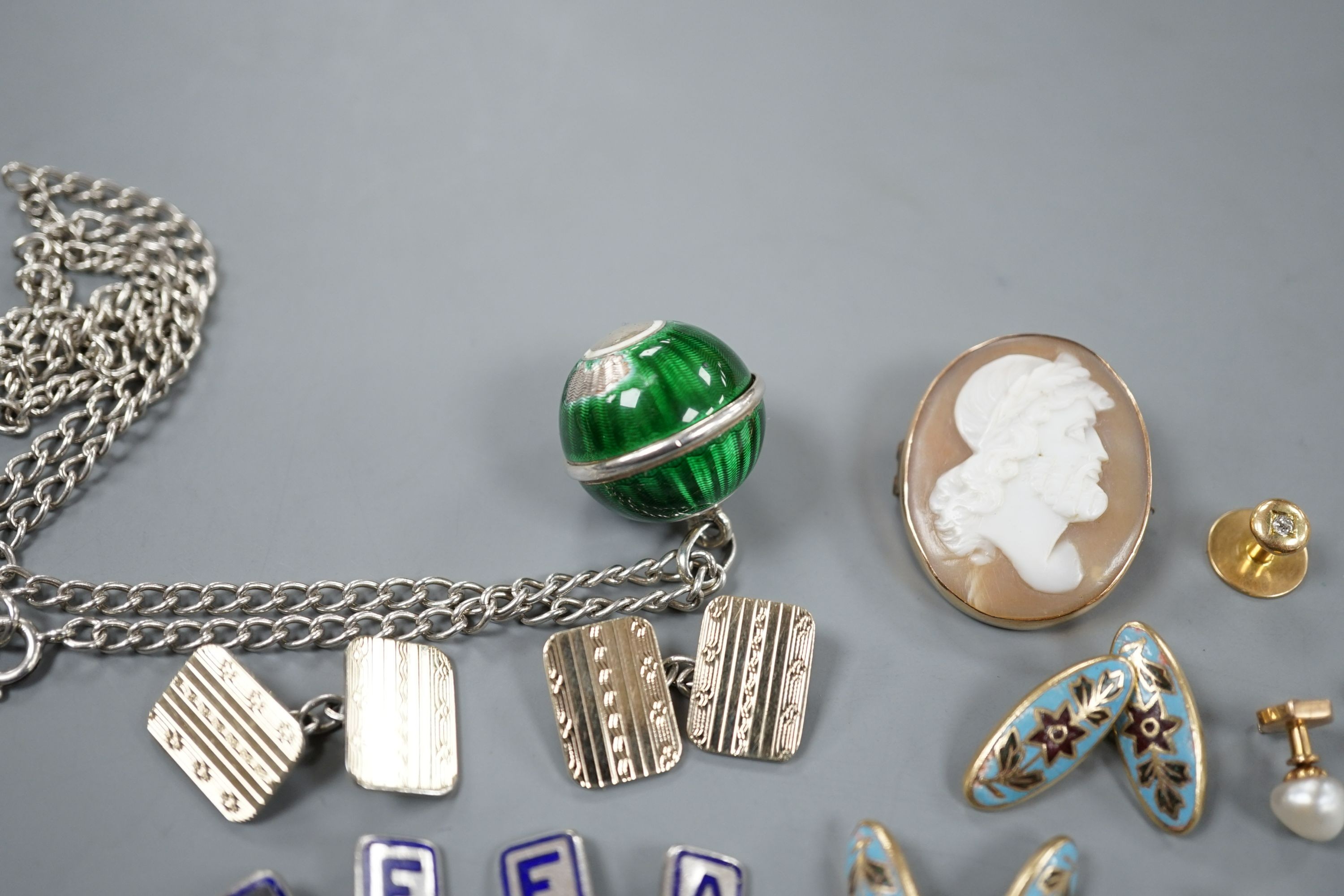 An early 20th century French white and yellow metal, green enamel(a.f.) set pomander, 19mm, on a white metal chain, three French (18ct poincon mark) and baroque pearl set dress studs, gross 3.5 grams, a diamond set 15ct